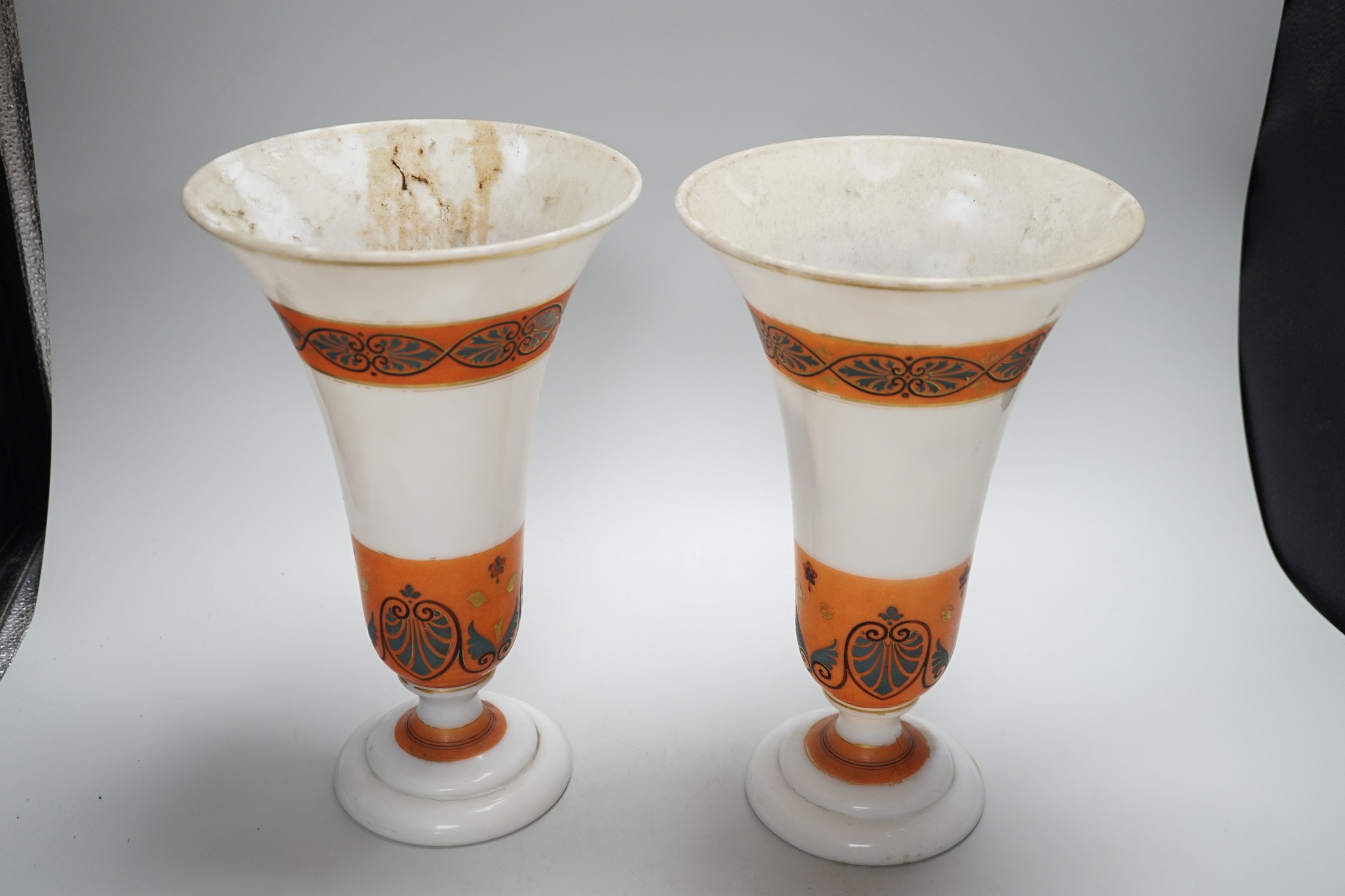 A pair of opaque glass anthemion vases, with orange decorative bands, 30cms high